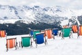 series of colored deckchairs are installed on the fresh snow Royalty Free Stock Photo